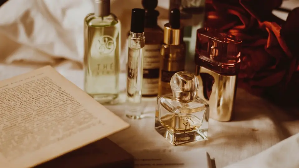 Libro aperto circondato da flaconi di profumo